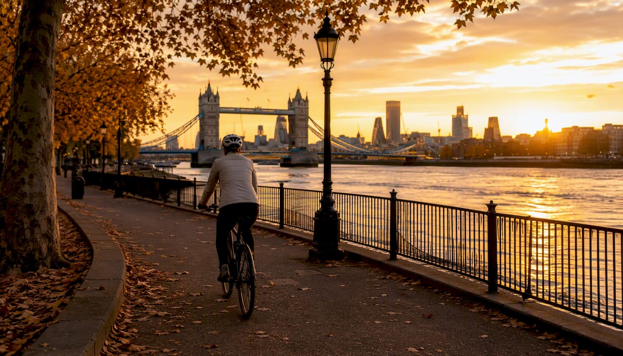 Cyclist on Thames riverside path at sunrise